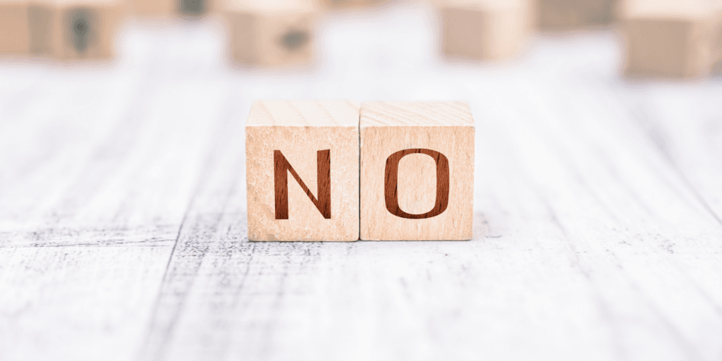 Be clear and don't waiver when turning down a second date. An image of two wooden blocks with the word "no" carved into them.