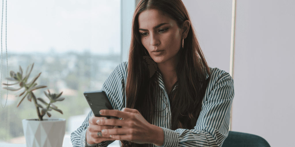 Don't ghost them. A woman looks seriously at her phone expecting a text from her date wondering if she will go on a second date.