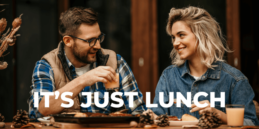 A young couple from the It's Just Lunch matchmaking service drinking cocktails and eating charcuterie.